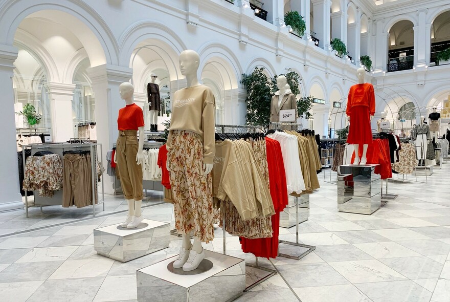 Racks of clothing and mannequins inside H&M store in the old Post Office building.