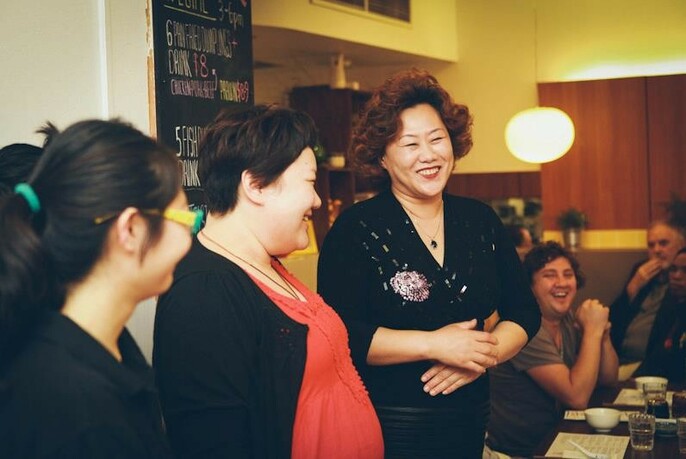 Smiling ShanDong Mama owner with staff and customers.