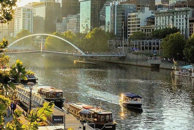 The Yarra River with water vessels, Southbank Boulevard and trees and buildings visible.