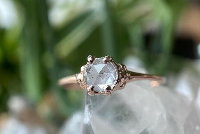 Ring containing white crystal.