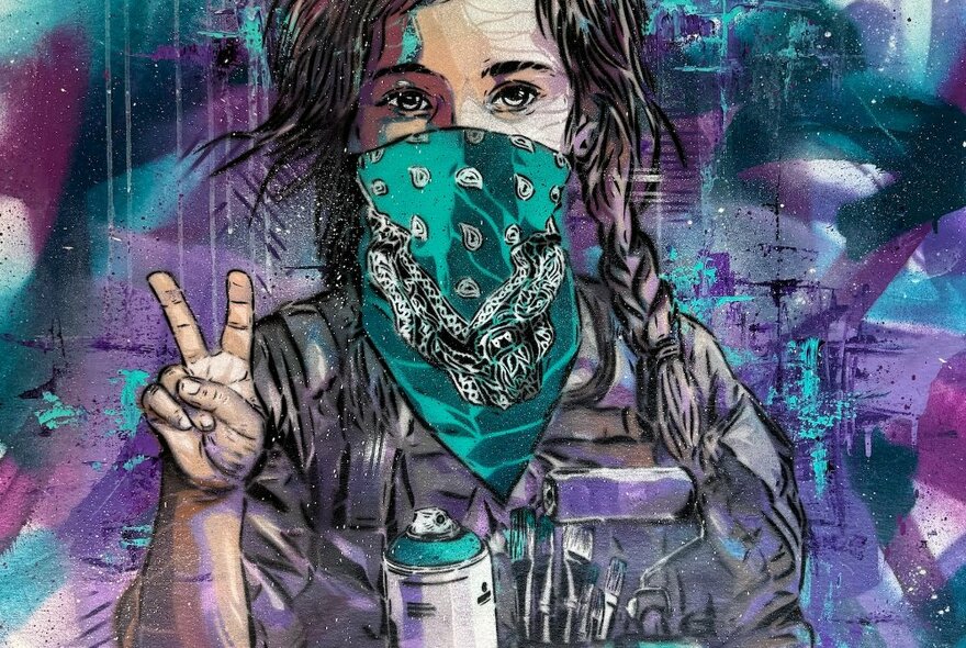 Street artist artwork of a child wearing a bandana, making a peace sign and holding a can of spray paint.