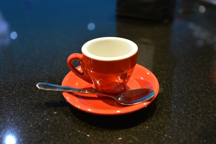 Small red coffee cup and saucer.
