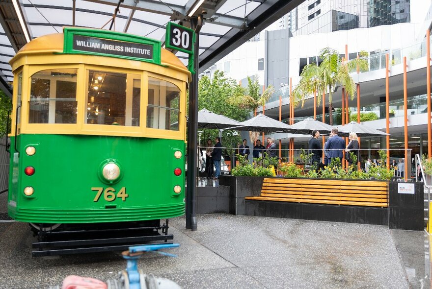 The heritage Melbourne Tram cafe, parked in an outdoor garden cafe setting with seating and umbrellas.