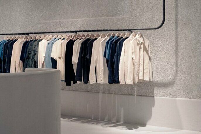 A rack of shirts in shades of white and blue. 