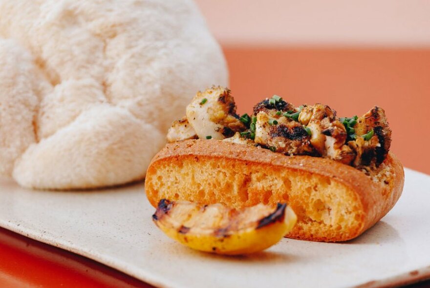 A toasted bread roll filled with mushrooms served on a plate.