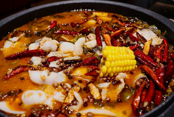 Pot of Chinese Sichuan food with lots of red chillies.