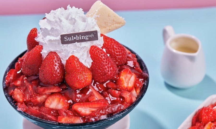 An ice cream dessert with strawberries and cream on top