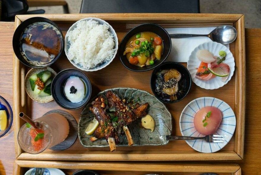 A wooden board filled with Japanese food