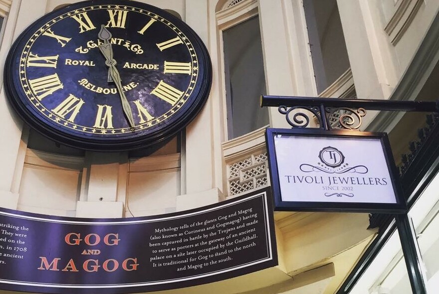 Gog and Magog clock and sign in the Royal Arcade.