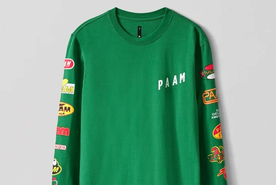 A green long sleeve tee with red and yellow logos running down the arms.
