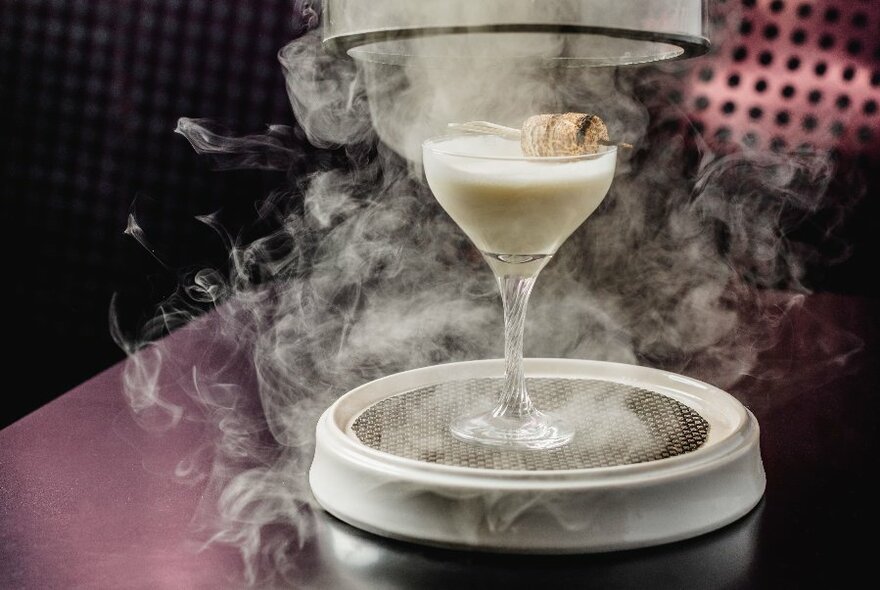 Mist surrounding a white cocktail.