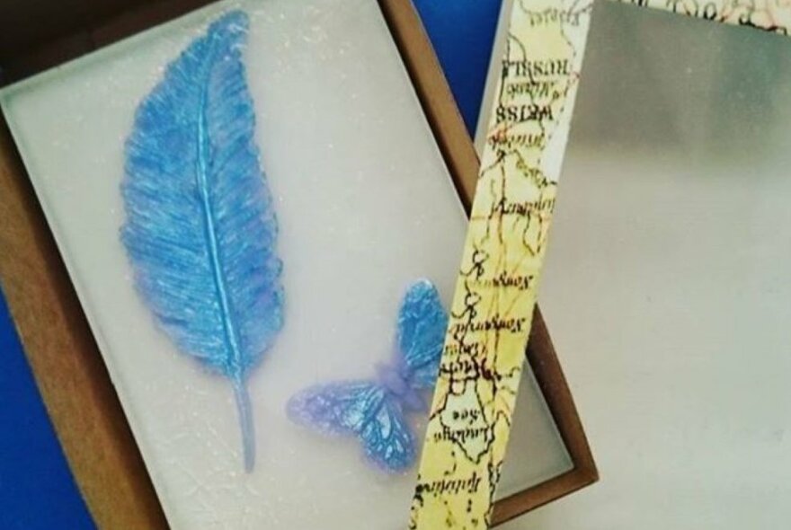 Blue feathers embedded into a white soap bar in a gift box.