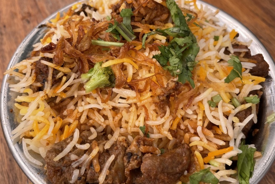 Indian biriyani meal with rice and meat.