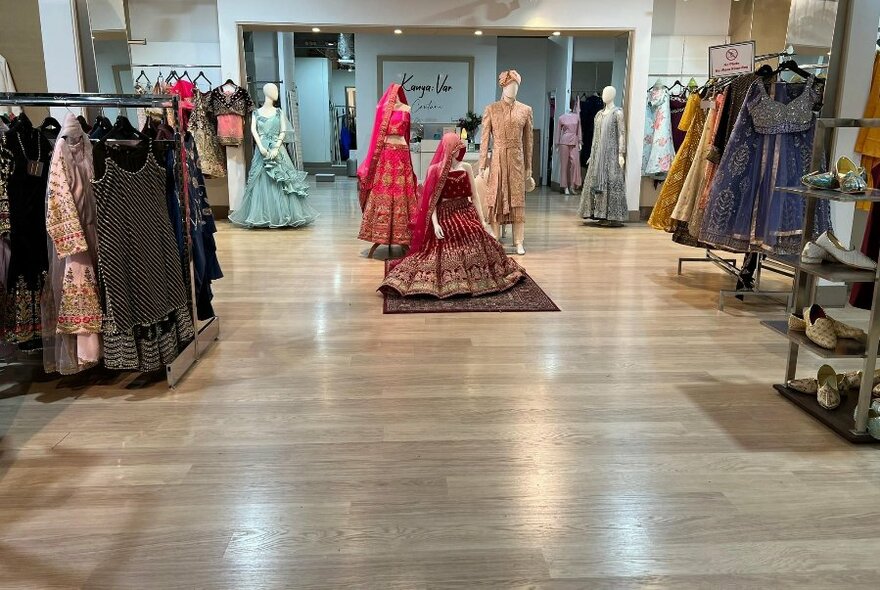 Spacious interior Kanya Var boutique, showing mannequins wearing outfits, and racks of clothing.