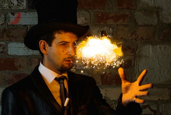 A magician in a top hat conjuring a puff of smoke and fire.