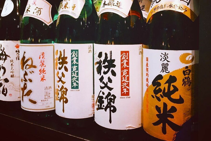 Bottles of sake lined up on a counter.