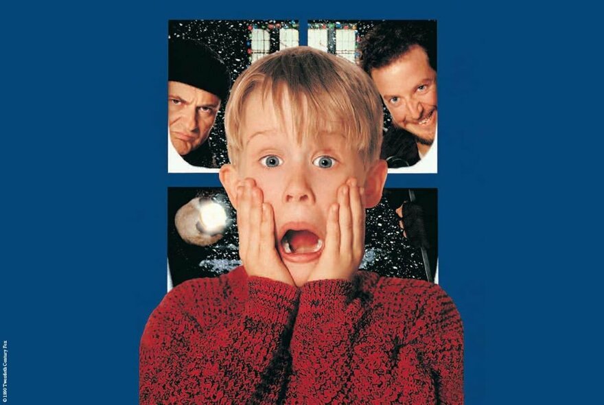 A still image from the movie Home Alone featuring a small boy with his hands to his cheeks and mouth wide open with two men looking menacing in the background. 