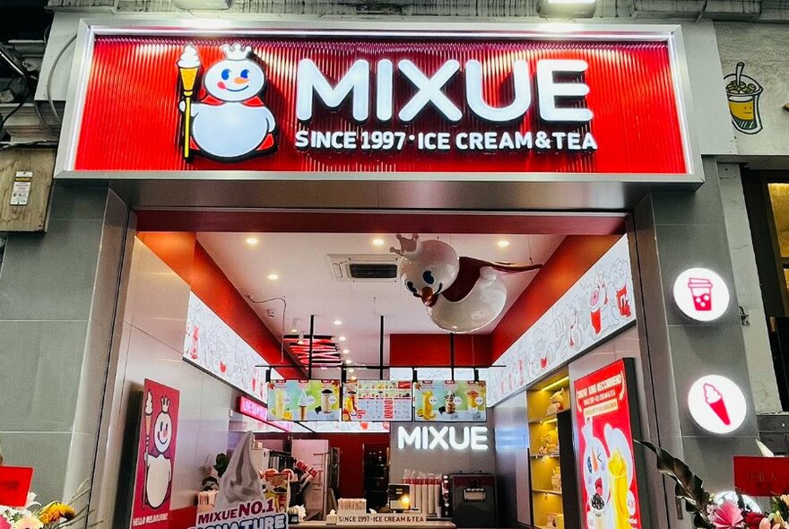 Street entrance to the Melbourne Mixue shop with exterior signage visible, and a glimpse into the interior.