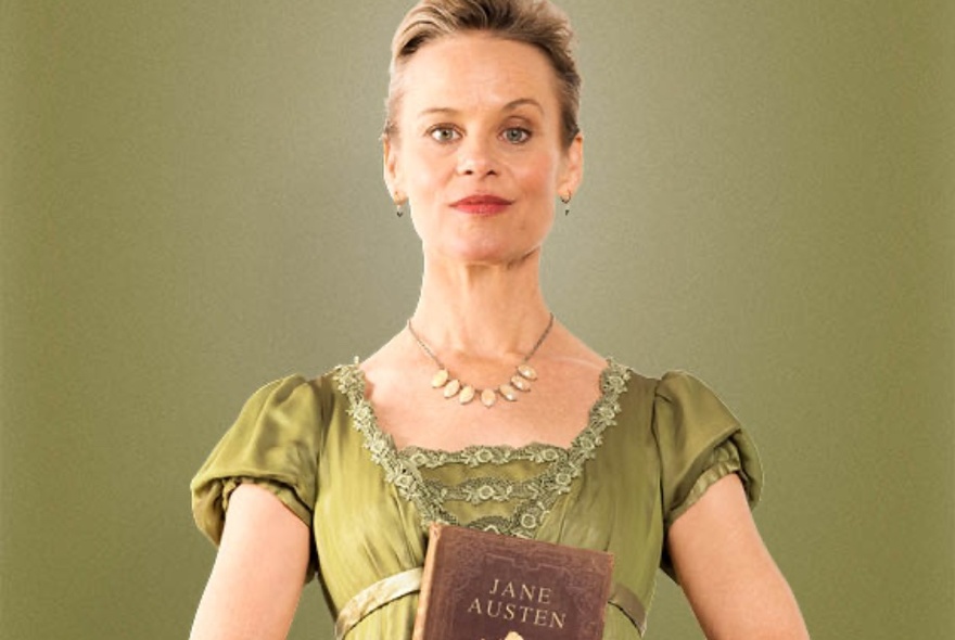 Actor Nadine Garner in a regency style green dress holding a copy of Pride and Prejudice. 