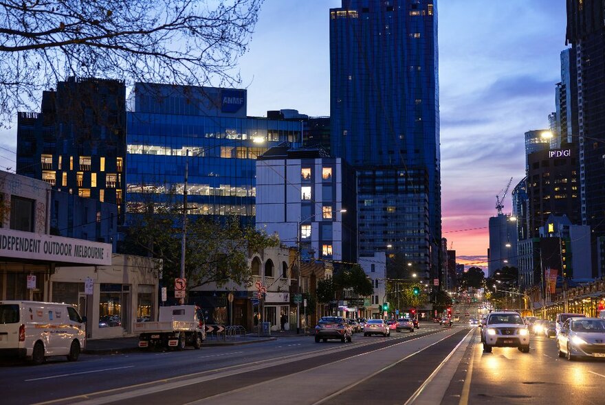 Buildings at dusk on Victoria Street with cars and sunset.