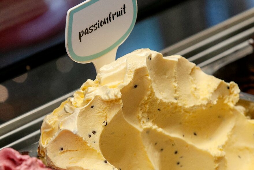 Close up of passionfruit gelato with small sign saying passionfruit.