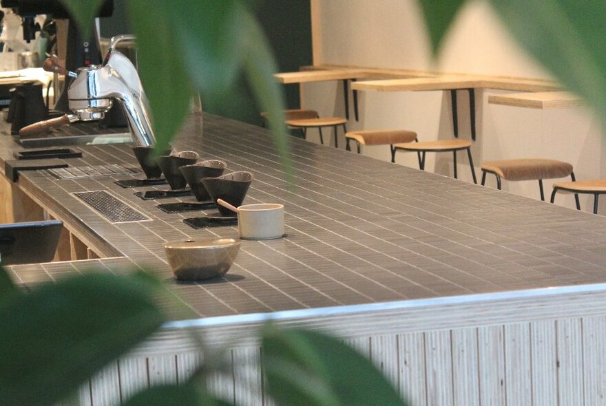 The interior of a coffee shop with a sink, bowls and stools