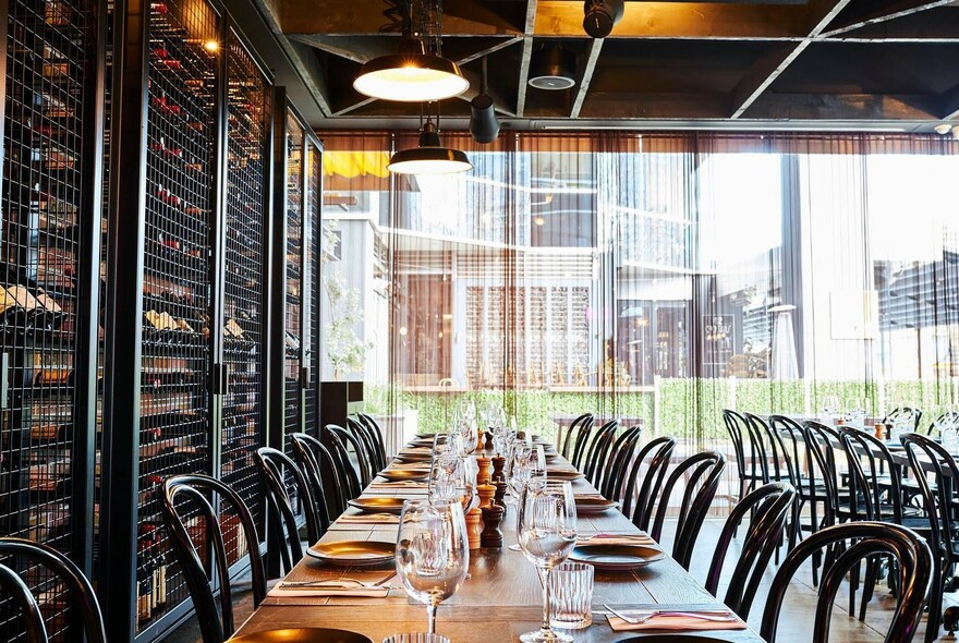Interior of Soho Restaurant & Bar with tables and chairs and a wall of wine.