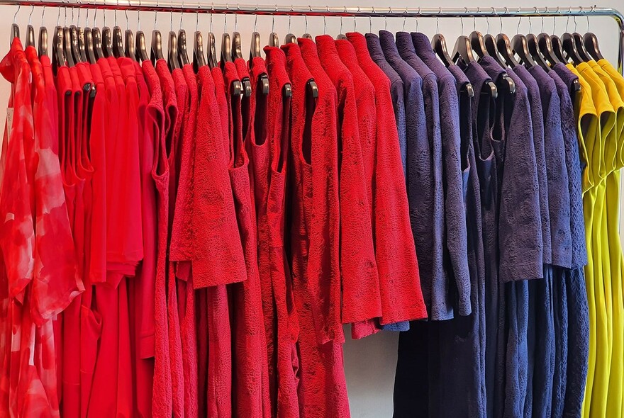 Brightly-coloured dresses on a rack.