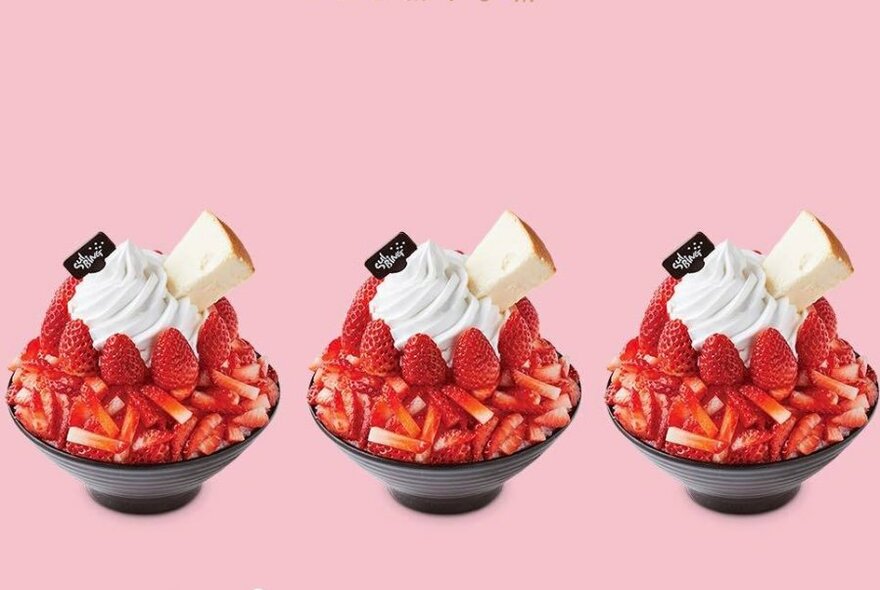 Three strawberry desserts in a row against a pink background.