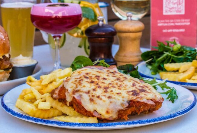 A parma on a plate with chips