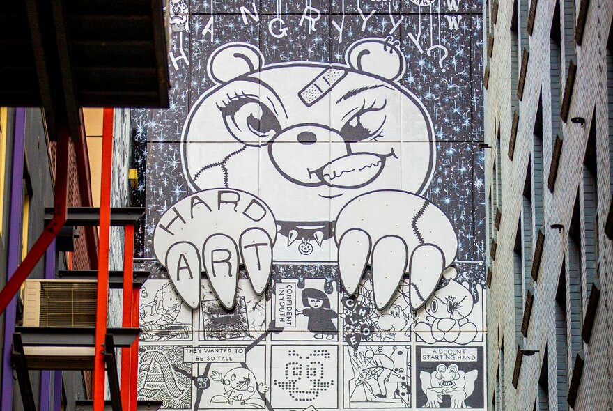 A street art mural designed to look like a comic book with a tough teddy bear.