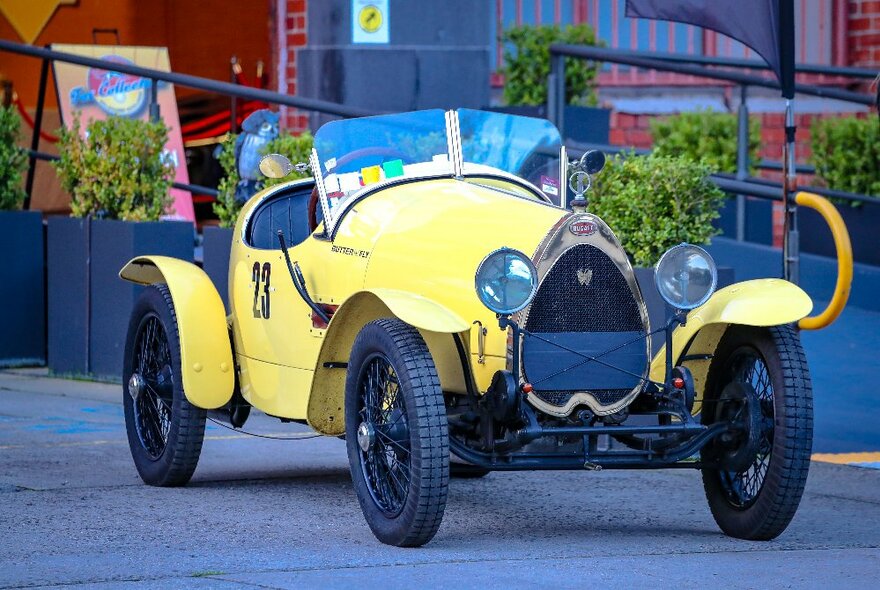 A yellow vintage car on display. 