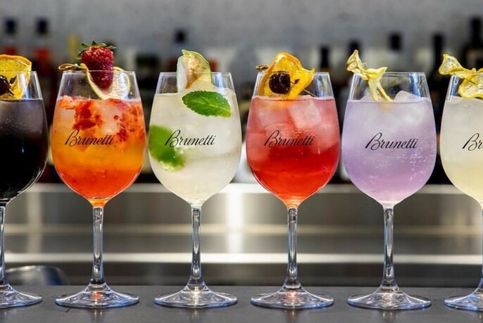 Glasses of variously-coloured drinks, all with garnishes.