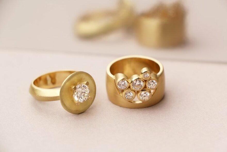 Two chunky gold rings with diamonds.