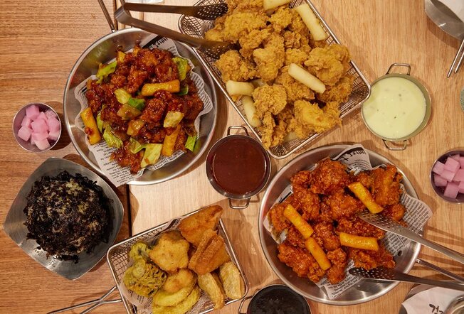 A table set with Korean dishes including fried chicken.