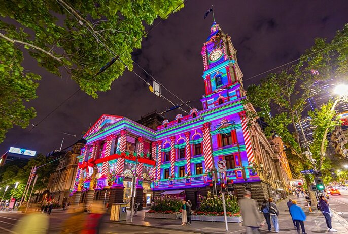 Melbourne Town Hall facade lit up in purple and green Christmas themed projections.
