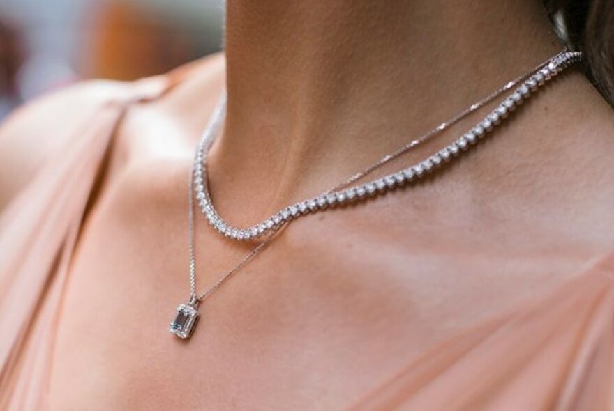 Model's neck with diamond and precious stone necklaces.