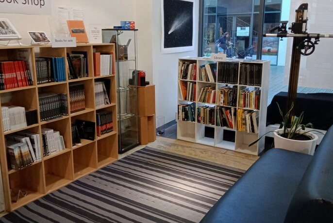 The store section of Magnet Galleries featuring art books for sale and a couch.