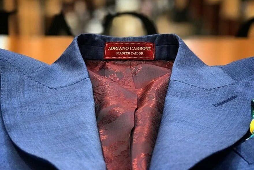 Blue suit with red lining, viewed from collar up.