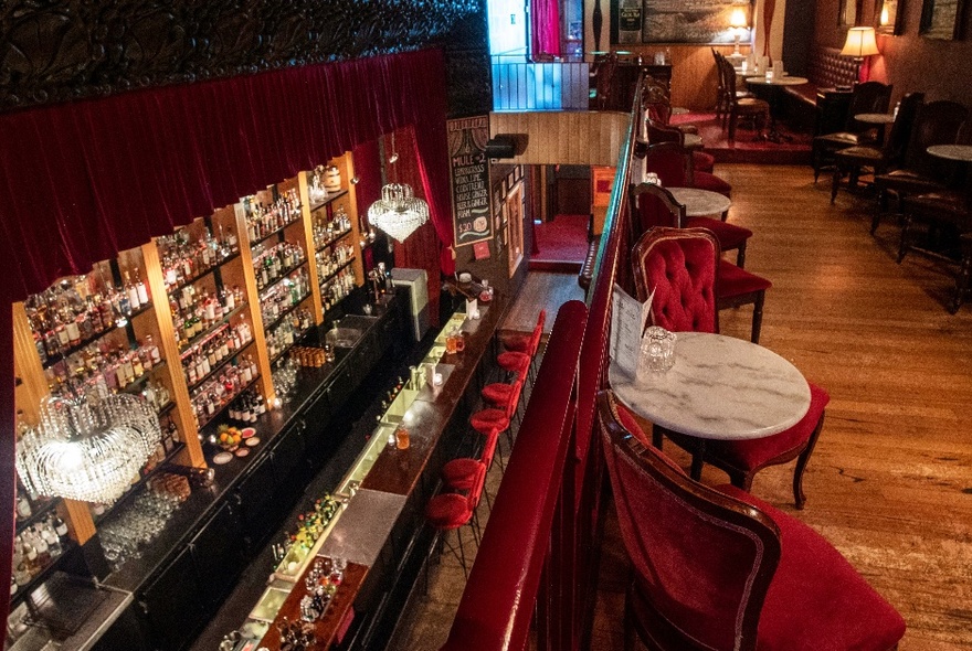 Interior of a speakeasy-style bar seen from the mezzanine.