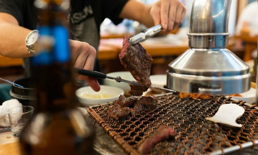 A person grilling meat in a restaurant