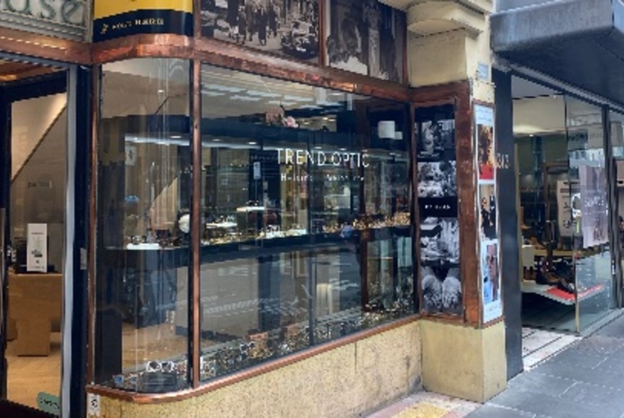The front window of the Trend Optic store, showing marble and brass from the historic building.