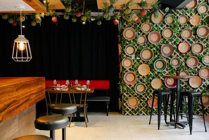 Bar stools and a wall decorated with African baskets.
