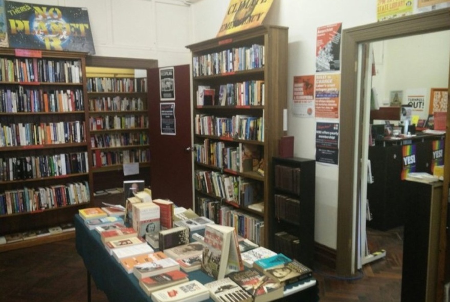Interior of New International Bookshop, with bookshelves and display table in centre.