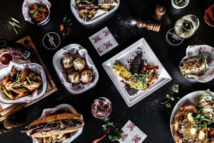 Overhead view of selection of dishes on black background.
