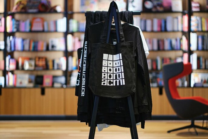 ACMI tote bag in a bookstore.