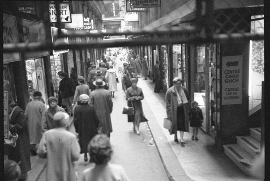 A busy laneway filled with stores and women shopping 