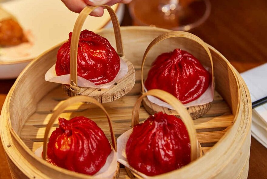 Red dumplings in a bamboo basket.