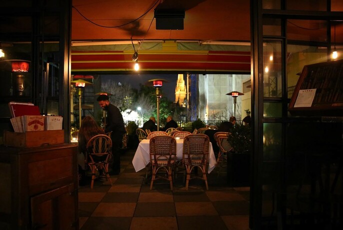 Siglo at night with tables and chairs and outdoor heating lamps.