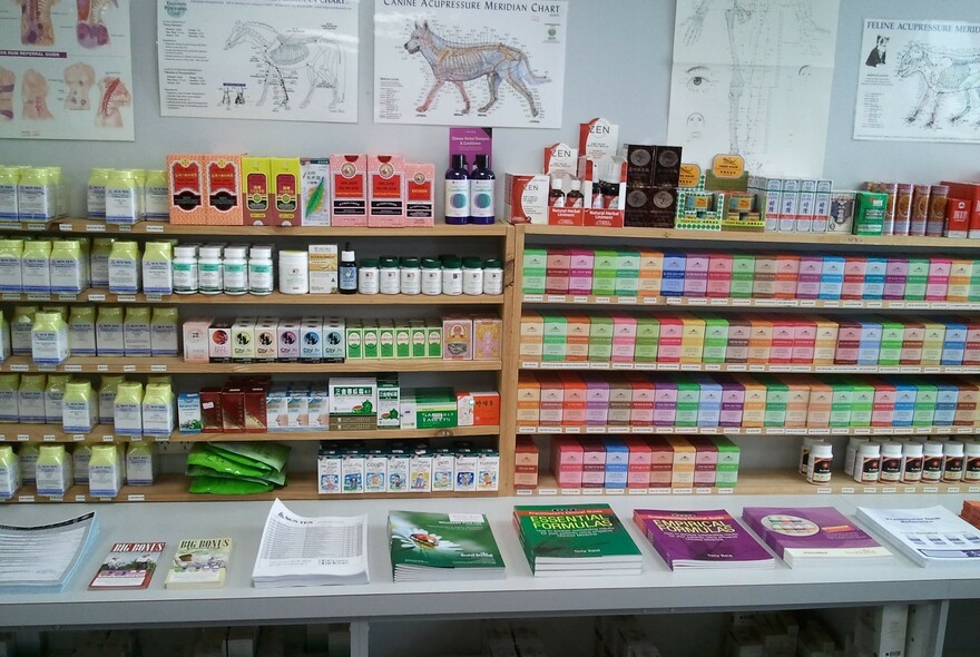 Display of books, and on shelves a range of packaged Chinese herbs.